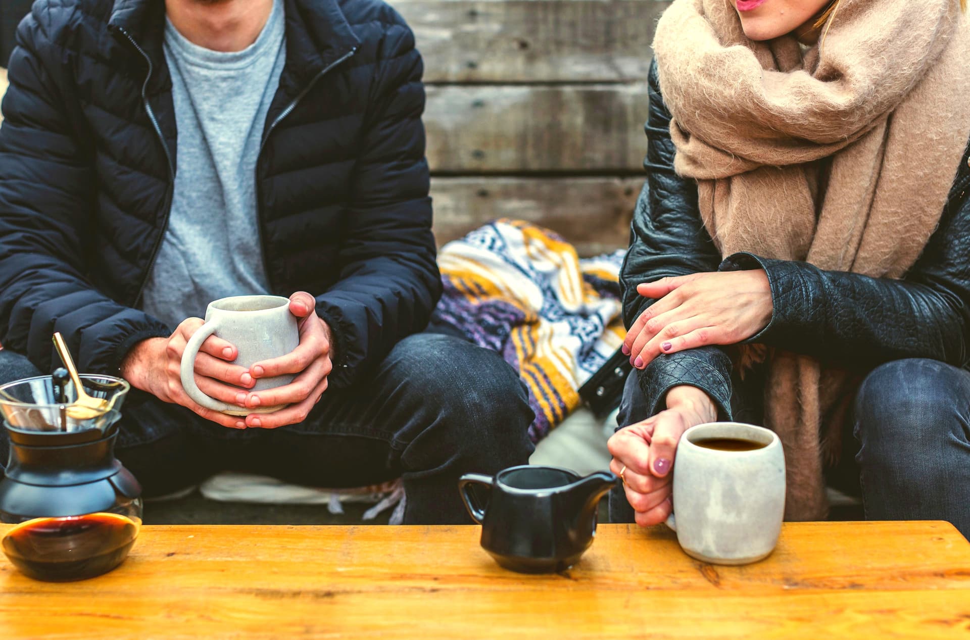 Two people holding mugs during a quiet conversation
